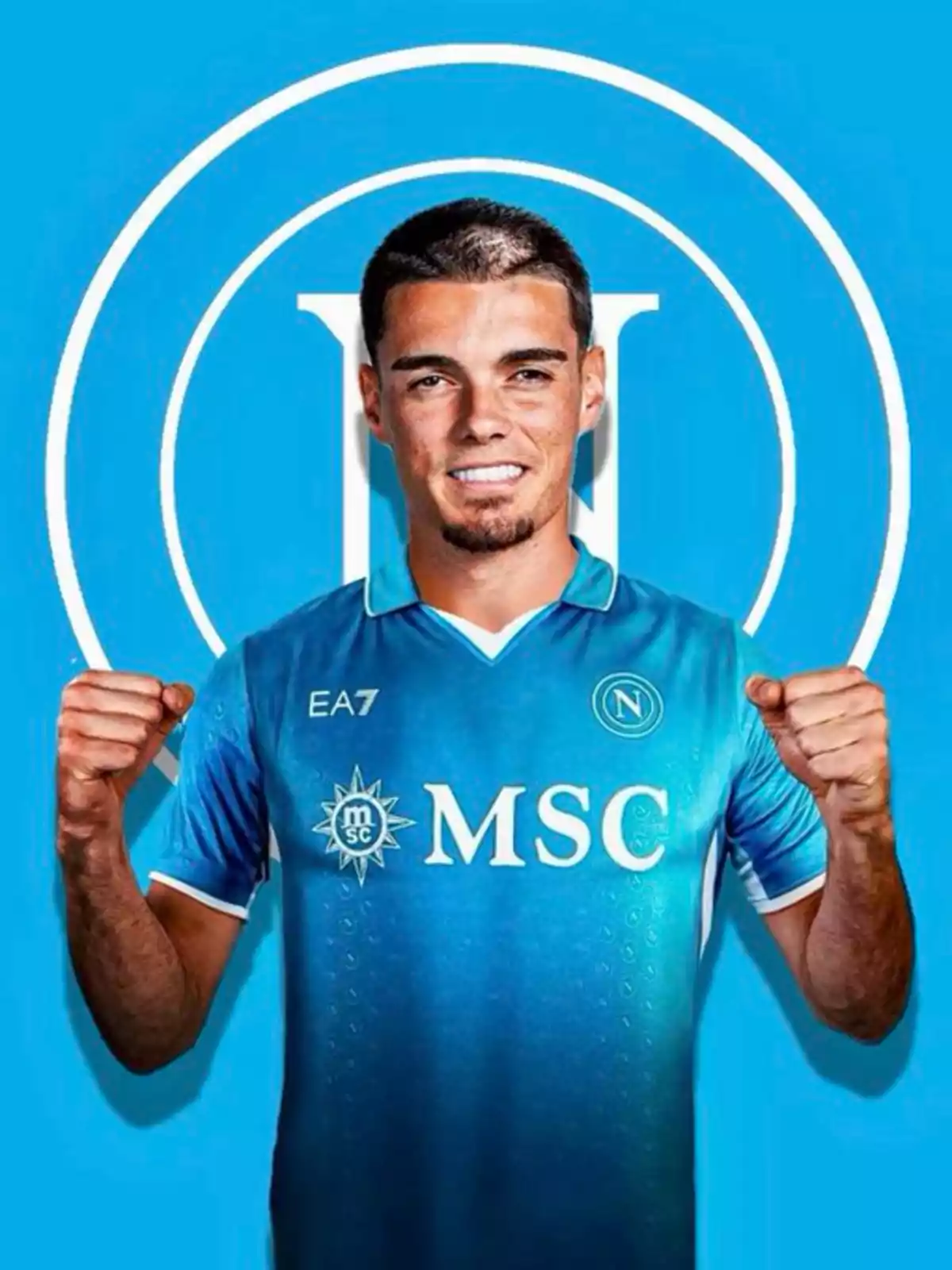 Futbolista con uniforme azul del Napoli celebrando con los puños levantados frente a un fondo azul con el logo del club