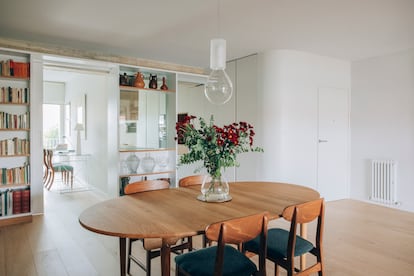 Anteriormente, en esta zona de acceso había un vestíbulo y un pasillo que rompían la conexión entre el salón, la cocina, algunas habitaciones y la terraza interior. La mesa de comedor es un diseño de Hans J. Wegner y la lámpara es de Mayice.