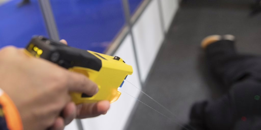 Un especialista en lucha libre se quita los arpones de una pistola táser durante su arresto.