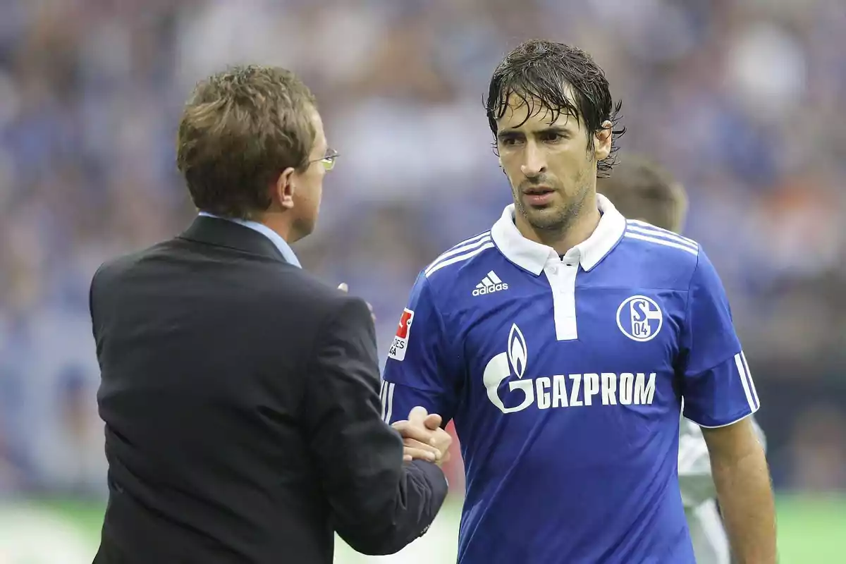 Un entrenador y un futbolista del Schalke 04 se dan la mano en el campo durante un partido Un entrenador y un futbolista del Schalke 04 se dan la mano en el campo durante un partido