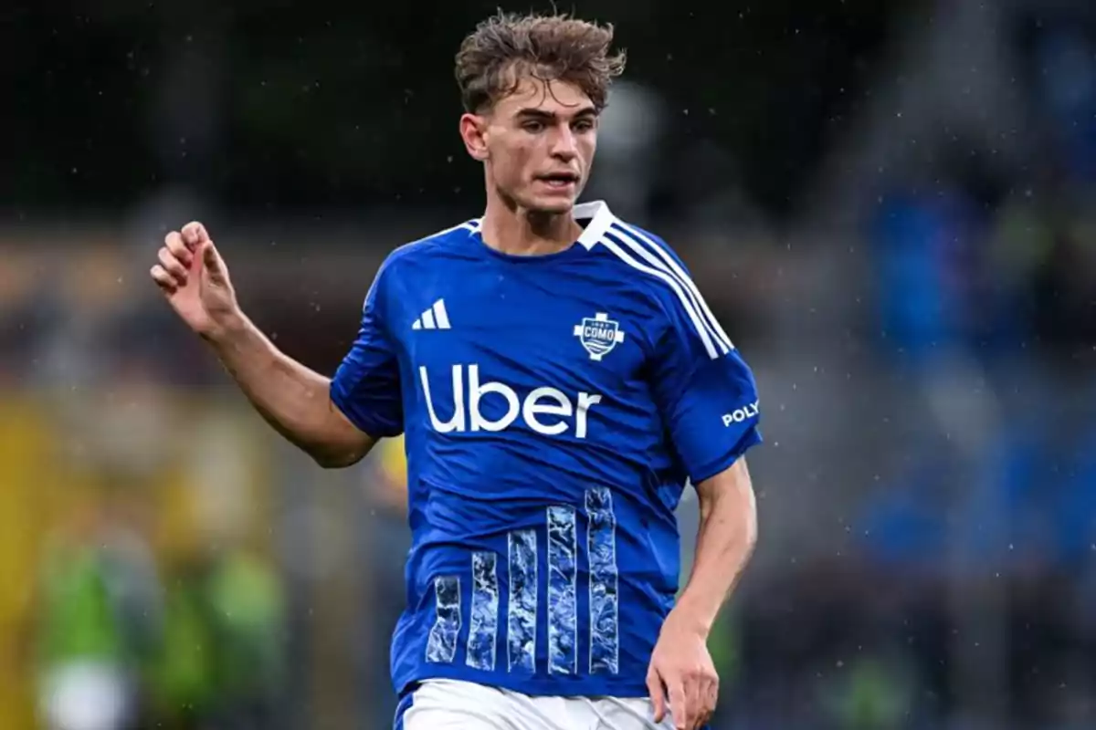 Un jugador de fútbol con camiseta azul del equipo Como en el campo de juego. Un jugador de fútbol con camiseta azul del equipo Como en el campo de juego.