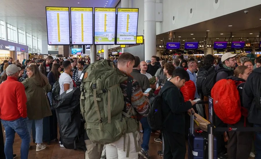 Pasajeros hacen cola en el aeropuerto de Bruselas, donde decenas de vuelos fueron cancelados tras un ciberataque que afectó a varios aeropuertos de Europa.