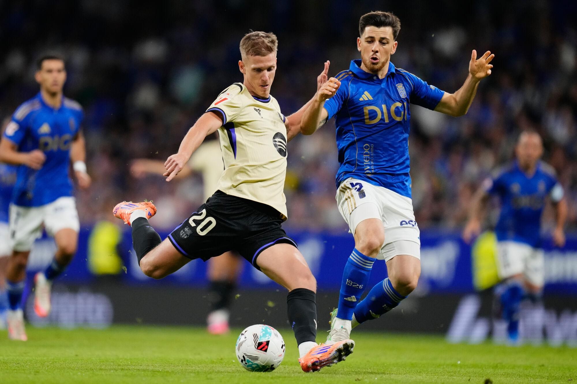 Dani Olmo del Barcelona compite por el balón con Alberto Reina del Real Oviedo durante un partido de La Liga en Oviedo.