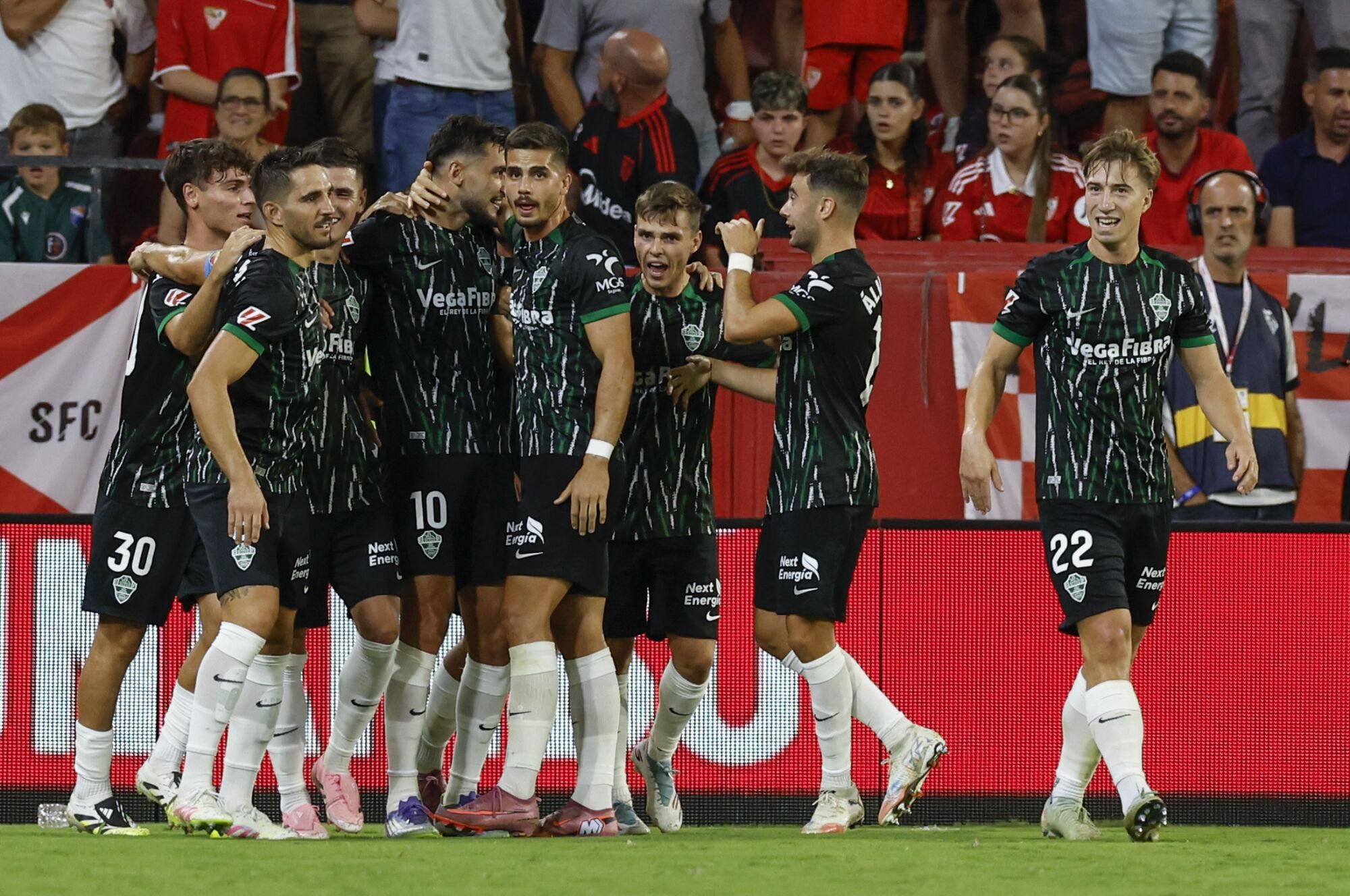 SEVILLA, 12/09/2025.- El delantero del Elche Rafa Mir (3-i) celebra con sus compañeros tras marcar el 1-2, durante el partido de la cuarta jornada de LaLiga EA Sports que Sevilla FC y Elche CF disputan este viernes en el estadio Ramón Sánchez-Pizjuán de la capital andaluza. EFE/Julio Muñoz