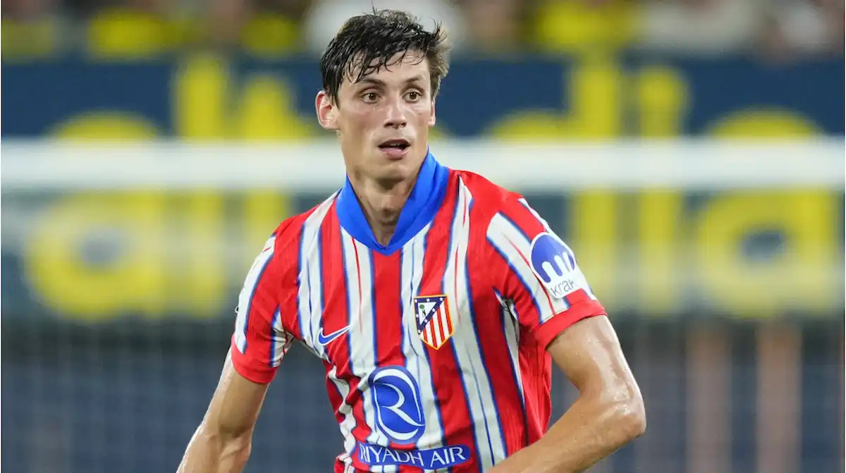Robin Le Normand con gesto serio en el banquillo del Atlético de Madrid mientras Marc Pubill calienta en la banda