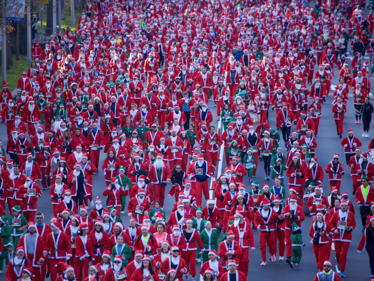 Más de 10,000 'Papás y Mamás Noeles' inundan Madrid durante la XIV Carrera Solidaria de El Corte Inglés.
