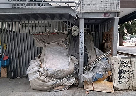 Imagen secundaria 1 - Arriba, una persona sin hogar cocina junto a su tienda de campaña; a la izquierda, estructura con enseres de personas sin hogar; y a la derecha, tres indigentes durmiendo en la plaza del Conde del Valle de Suchil
