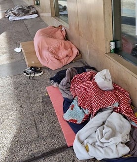 Imagen secundaria 2 - Arriba, una persona sin hogar cocina junto a su tienda de campaña; a la izquierda, estructura con enseres de personas sin hogar; y a la derecha, tres indigentes durmiendo en la plaza del Conde del Valle de Suchil