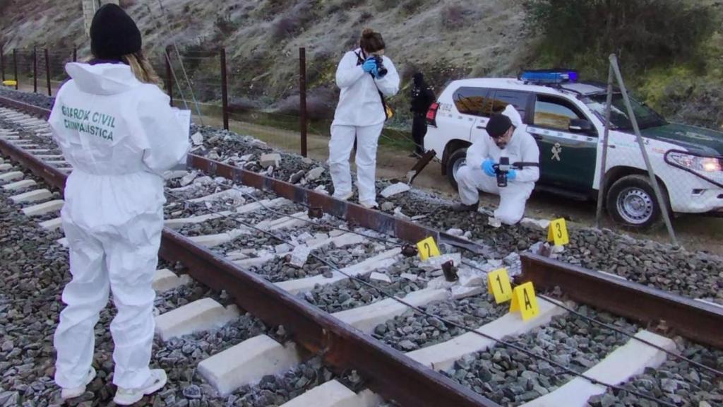 Los investigadores de la Guardia Civil fotografían el raíl roto que causó el accidente de Adamuz (Córdoba).