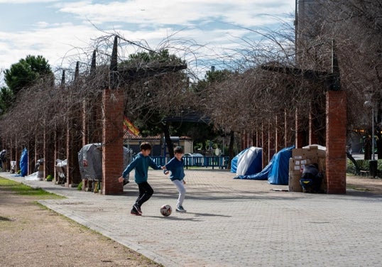 Dos niños juegan al fútbol en el parque de Martin Luther King, donde pasan la noche una decena de personas sin hogar.