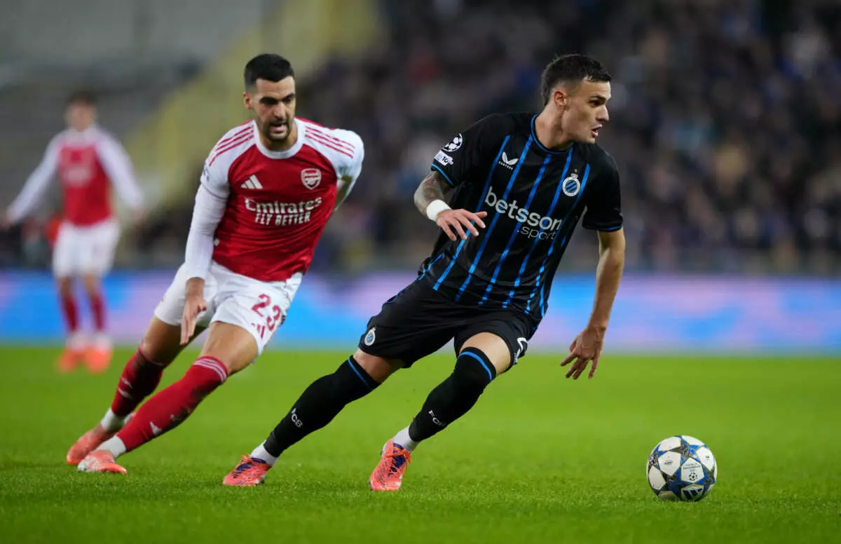 BRUGES, BELGIUM - DECEMBER 10: Aleksandar Stankovic of Club Brugge runs with the ball whilst under pressure from Mikel Merino of Arsenal during the UEFA Champions League 2025/26 League Phase MD6 match between Club Brugge KV and Arsenal FC at Jan Breydelstadion on December 10, 2025 in Bruges, Belgium. (Photo by Alex Bierens de Haan - UEFA/UEFA via Getty Images)